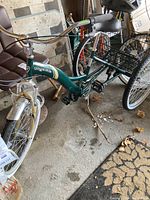 Front-side view of green Bayside tricycle showing full frame, front wheel and part of rear basket