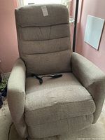 Front view of grey-beige La-Z-Boy electric recliner rocker chair with remote on seat