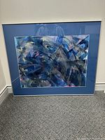 Front view of framed abstract artwork leaning against a wall showing the overall size and color scheme of the piece.