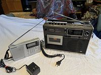 Full view of both radios side by side on table, showing size and antenna condition