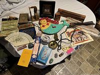 Full assortment showing tarot cards, incense, incense burners, decorative carved items, pouches, fan, and other spiritual objects spread on table.