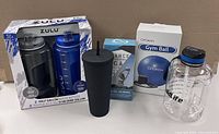 Full lot showing water bottles, studded tumbler, gym ball, and training ball boxes