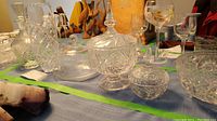 Photo showing crystal covered bowls, decanter, covered butter dish, and some glassware on a table