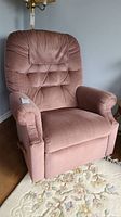 Front view of dusty rose fabric La-Z-Boy rocker recliner chair with tufted detail on the backrest and cushioned arms.