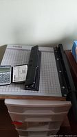 Dahle paper trimmer with three-hole punch and Canon FC-45S calculator on top, showing size and condition.