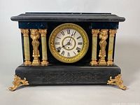 Front view of Seth Thomas mantel clock showing clock face with Roman numerals, columns with celluloid finish, and gold-tone decorative feet.