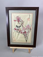 Full view of the framed Chinese watercolor painting on silk with the magnolia flower and butterfly composition.