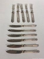Photo showing forks and knives arranged, highlighting overall condition and confirm set composition.