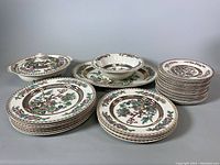 Full view of all dishes including stacked dinner plates, dessert plates, covered, open serving bowls and platter.