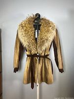 Front view of vintage ladies mink fur and suede jacket on mannequin, showing fur collar and suede belt tied at waist.