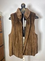 Front view of vintage brown sheared beaver fur vest on mannequin, showing collar and front closure.