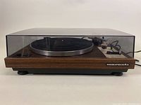 Front view with dust cover closed showing walnut plinth and Marantz logo