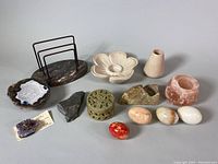 Overview of entire lot showing a variety of natural stone items including geodes, marble eggs, candleholders, carved boxes, and letter holder.