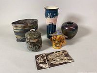 Group photo of the pottery lot showing all six items including the vase, planter, bust, small pot, and textured pottery pieces.