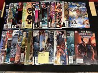 Photo of 50 comic books in mostly high grade condition featuring Marvel and DC superhero titles, arranged in two rows showing cover art and spines.