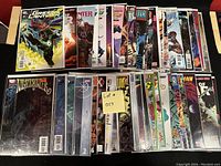 Photo showing 50 comic books laid out in two rows, bagged and boarded, featuring titles Green Lantern, Sgt. Rock, Martian Manhunter, GI Joe, Micronauts, X-Men, Submariner, Teen Titans, and Miracle Man.