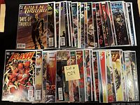 Photo of assortment of 50 comic books bagged and boarded, showing multiple titles from DC and Marvel including Green Arrow, Flash, and Fantastic Four.