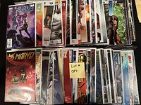 Photo showing stacked bagged and boarded comic books including Nova and Ms. Marvel covers visible.