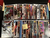 Photo of about 50 comic books including Wolverine, Batman, Thor, Wonder Woman, Spider-Man and more, all bagged and boarded for condition preservation.
