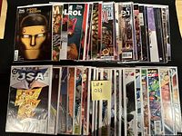 Photo showing the full lot with comics neatly arranged in two rows, all bagged and boarded, with visible titles including Doom Patrol, Justice League, JSA, and various heroes from DC and Marvel.