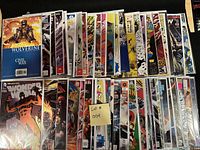 Top view of 50 comics arranged in two rows, bagged and boarded, showing covers from Wolverine, X-Men, Wonder Woman and others.
