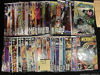 View of two rows of 50 comics, bagged and boarded, showing titles including DC's Green Lantern, Green Arrow, Metal Men, Gotham Academy, Grayson, and Valiant's Micronauts.