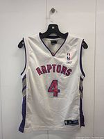 Front view of white Chris Bosh Toronto Raptors jersey, showing Raptors text and number 4