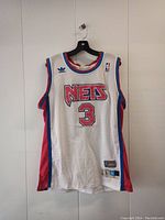 Front view of Dražen Petrović New Jersey Nets basketball jersey size L showing white mesh fabric, red and blue trim, Adidas branding, NBA patch, and number 3 on front with NETS team name.