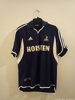 Front view of navy blue soccer shirt showing Holsten sponsor, Adidas logo, and Tottenham Hotspur crest