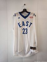Front view of the white Lebron James basketball jersey showing EAST text, number 23, Adidas and KIA logos.