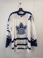 Front of white and blue Steve Thomas Toronto Maple Leafs hockey jersey with number 32 and letter A on chest.