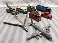 Eight toys arranged on striped backdrop showing all eight vehicles and planes