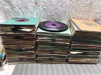 Three stacks of 7-inch records in paper sleeves arranged side by side