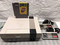 NES console with Super Mario Bros. 3 cartridge inserted and two controllers