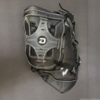 Top side view of the black Diablo baseball glove with the 'D' logo on the web and white stitching.