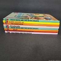 Side view showing the spines of the eight hardcover books with titles and colorful design