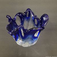 Front angle view of cobalt blue Murano glass vase with ruffled edges blending to clear base.