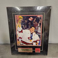 Front view of the framed photo plaque showing Mario Lemieux holding his gold medal in Team Canada jersey. The plaque and frame are visible with original plastic cover wrapped around with some scuffs.
