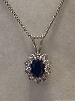 Necklace with pendant displayed against neutral gray background showing chain style and pendant shape