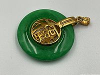 Close-up of pendant front showing green jade circle and gold 'Fu' character medallion