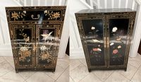 Front view of two black lacquer chinoiserie cabinets side by side showing painted floral and bird motifs