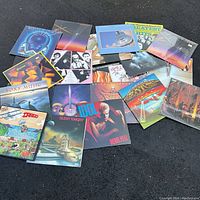 Overview of multiple album covers laid out on asphalt