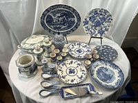 Overhead view of entire arrangement of plates, platters, bowl, tureen, pitchers, egg cups and accessories on table.