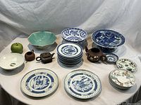 Wide overview of entire lot showing plates, bowls, compote and teapots.