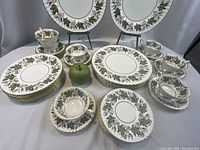 Overview of all dinner service pieces arranged on table showing plates and cups.