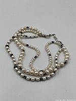 Pearl and silver bead necklace coiled to show full length
