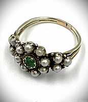 Close-up angled view showing seed pearls and central emerald.