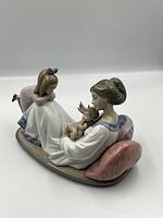 Oblique front view of figurine showing mother, baby, and child leaning