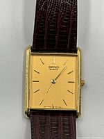 Front view showing gold dial with Seiko Quartz logo and baton markers