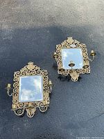 Pair of sconces hanging on a dark wall showing both units and overall size